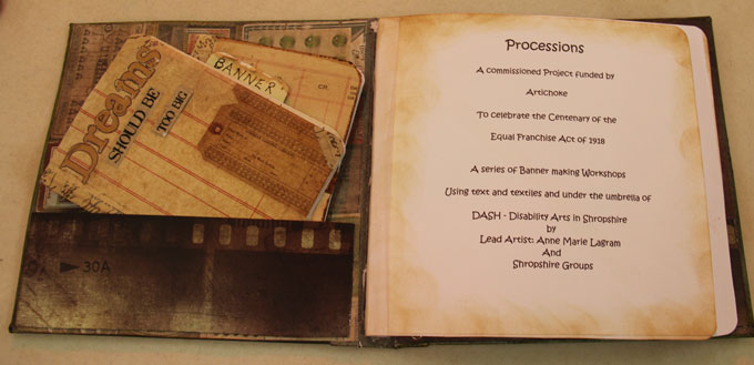 Photo of a handmade journal by Jean Green for the DASH PROCESSIONS project.  The inside cover has a pocket which is holding notepads, one says 'Dream should be too big'.  The next page tells us about the PROCESSIONS project.
