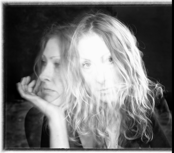 A black and whire double exposure headshot. Anna is looking to the right with her chin resting on her hand as well as looking at the viewer