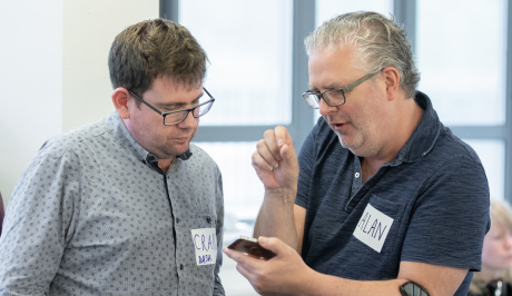 Cultivate mentor, Craig Ashley, deep in conversation with mentee, Alan Hopwood. They are both looking at a mobile device.
