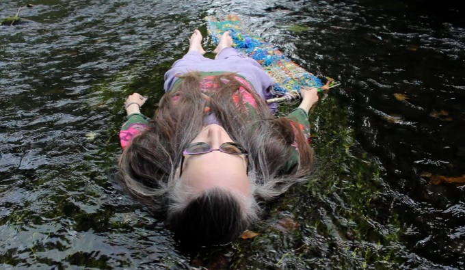 A close up of a woman laid down on the river. 